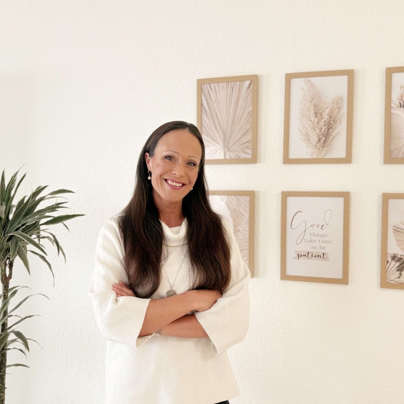 Porträt von Melanie Christl, Psychologische Beraterin, lächelnd in ihrer Praxis in Seligenstadt vor einer Wand mit Bildern